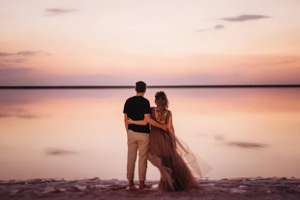 Gün Batımında Pembe Tuz Gölünün Kıyısında Bir Adam Bir Kız — Stok fotoğraf