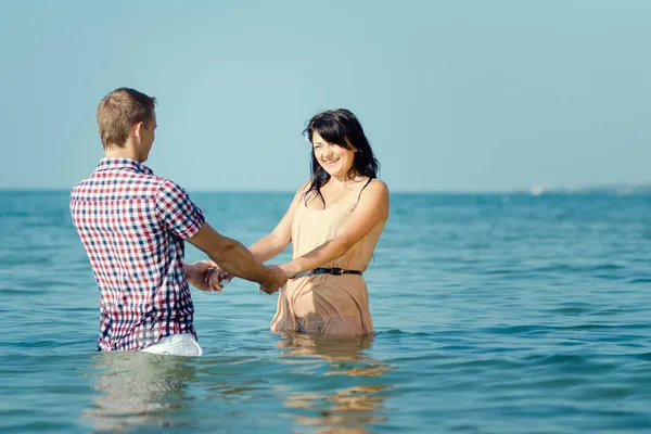 一个男的和一个女的沿着海滨散步 在水里游泳 — 图库照片