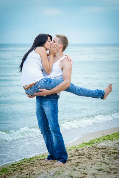 男と女がジーンズと海岸の白いTシャツを着て — ストック写真