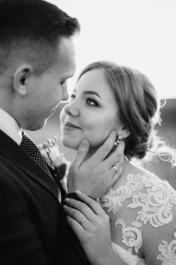 Damat ve gelin açık havada buğday yeşili tarlalarda yürür.