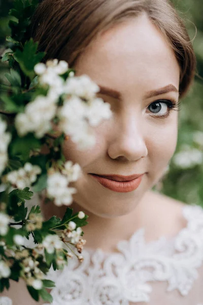 Panna Młoda Bukietem Ślubnym Lesie Pobliżu Krzaków Kwitnących Białymi Kwiatami — Zdjęcie stockowe