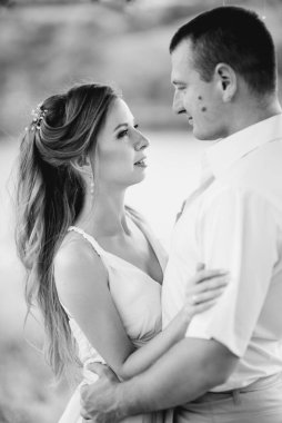 Genç bir çift, bir kız ve bir adam nehrin arka planında yürüyorlar.