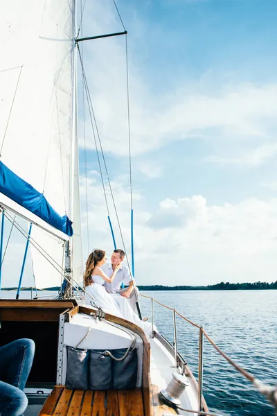 一对年轻夫妇坐在一艘白色游艇上 — 图库照片