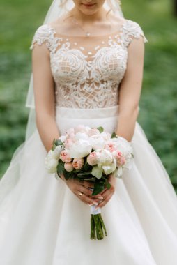 Taze doğal çiçekler ve yeşillik dolu zarif bir düğün buketi.