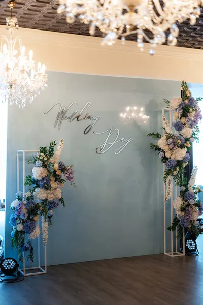 blue ceremony area with floral arrangements and lettering