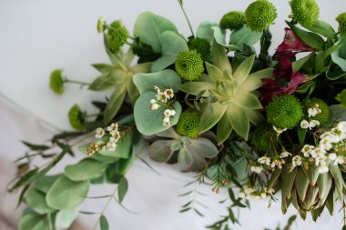 Doğal çiçekler ve yeşil elementlerden yapılmış zarif düğün süsleri.