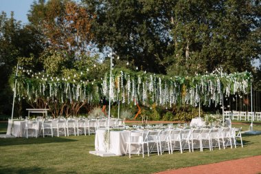 Dekoratif unsurlarla, atmosferik dekorlarla dolu bir düğün için bahçede ziyafet.
