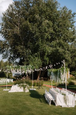 Dekoratif unsurlarla, atmosferik dekorlarla dolu bir düğün için bahçede ziyafet.