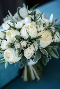 Taze doğal çiçekler ve yeşillik dolu zarif bir düğün buketi.