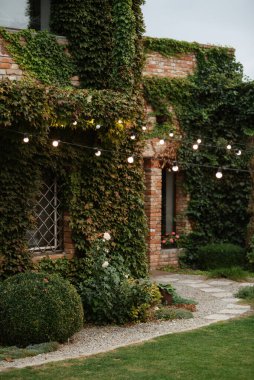 Yeşil üzümlü kırmızı tuğlalı villa restoranı.