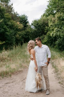 Çam ormanında yürüyüşe çıkmış genç bir çift.