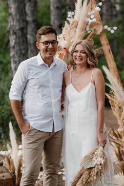 Bir adamla bir kızın düğün seremonisi Orman yolunda bir kemerin arka planına karşı