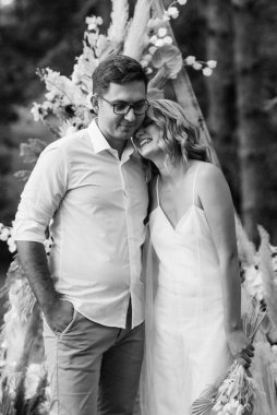 Bir adamla bir kızın düğün seremonisi Orman yolunda bir kemerin arka planına karşı