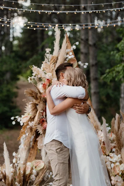 Bir adamla bir kızın düğün seremonisi Orman yolunda bir kemerin arka planına karşı