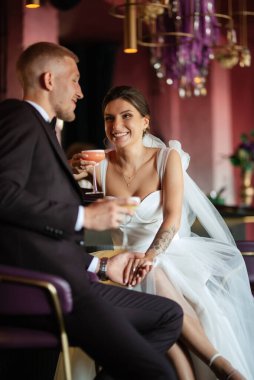 Gelin ve damat, canlı bir atmosferde bir kokteyl barında.