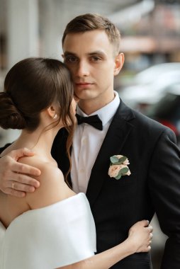 Genç çift, gelin ve damat, yağmurda yürüyen beyaz kısa elbiseli.