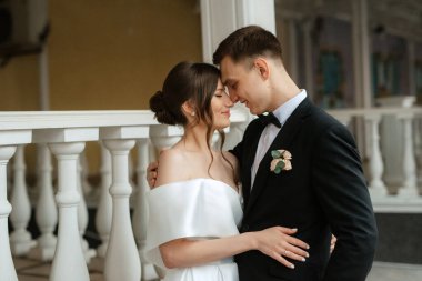 Genç çift, gelin ve damat, yağmurda yürüyen beyaz kısa elbiseli.