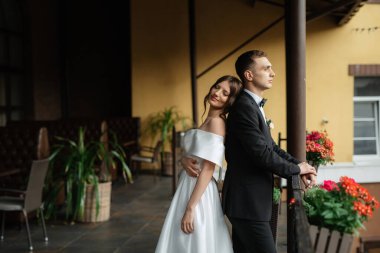 Genç çift, gelin ve damat, yağmurda yürüyen beyaz kısa elbiseli.