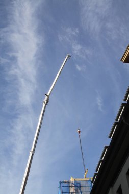 Zanaatkar, marangoz, çatı tamircisi, yüksek bir binanın çatısının tamamlanmasına hazırlanıyor.