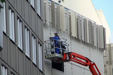 Paderborn, Kuzey Ren-Westphalia, Almanya, Ekim 28. 2020, zanaatkar platformun üzerinde duruyor ve bir cephede çalışıyor.