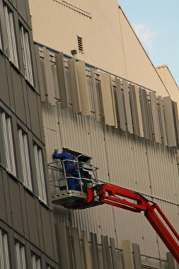 Paderborn, Kuzey Ren-Westphalia, Almanya, Ekim 28. 2020, zanaatkar platformun üzerinde duruyor ve bir cephede çalışıyor.