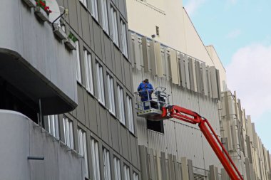 Paderborn, Kuzey Ren-Westphalia, Almanya, Ekim 28. 2020, zanaatkar platformun üzerinde duruyor ve bir cephede çalışıyor.