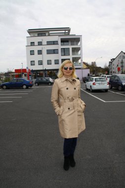 Park yerinde poz veren güneş gözlüklü çekici bir kadının portresi.