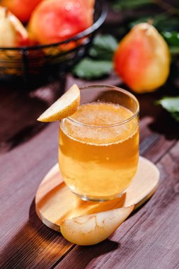 Armut içeceği ahşap bir masada, cam üzerinde armut dilimi