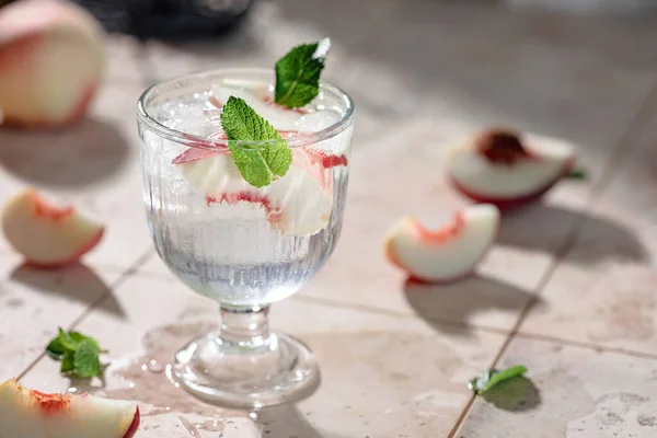 Preparation of a refreshing summer drink from peaches, ice and mineral water