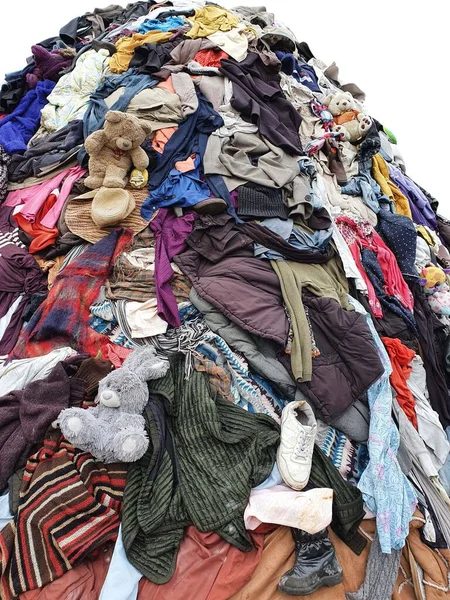 large pile stack of textile fabric clothes and shoes. concept of recycling, up cycling, awareness to global climate change, fashion industry pollution, sustainability, reuse of garment