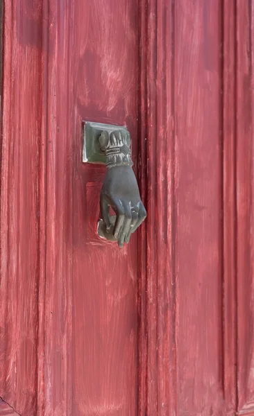 Maçaneta na forma de uma mão de mulher em uma porta vermelha na Grécia — Fotografia de Stock
