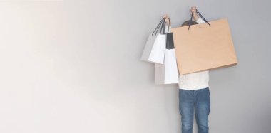 Küçük çocuk alışveriş torbalarını kaldırır ve onların arkasına saklanır. Modelleme. Kara Cuma ve Siber Pazartesi konsepti. Pankart