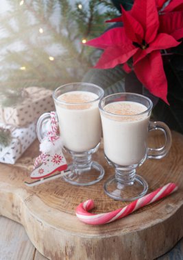 Geleneksel Noel içkisi yumurta likörü, oyuncak patenler ve karamel kamışı.