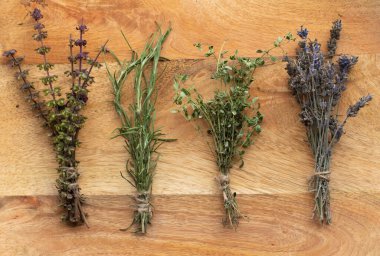 Ahşap arka planda kurutulmuş lavanta, kekik, biberiye ve fesleğen. Aromaterapi ve Geleneksel Tıp Konsepti. 