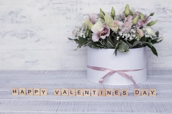 Flowers in a round box on a light wooden background and the inscription Happy Valentines Day — 图库照片