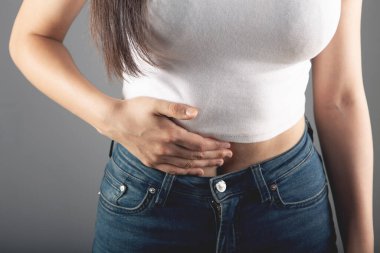 Genç bir kadının midesi ağrır.