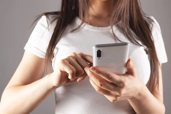 Mujer Joven Presiona Pantalla Del Teléfono Sobre Fondo Gris — Foto de Stock