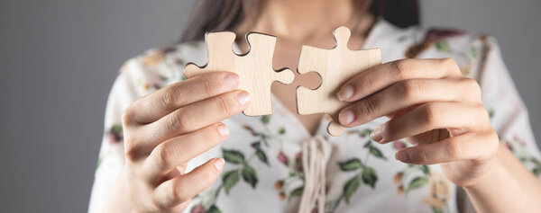 young woman holding puzzle pieces