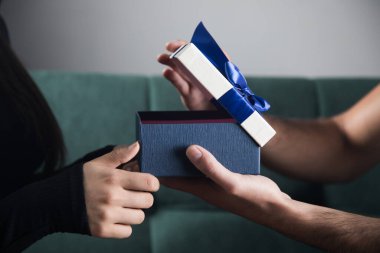 Bir erkek, koltukta oturan bir kadına hediye verir. Aile tatili konsepti