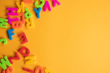 Plastik harfler turuncu masaya saçılmış.