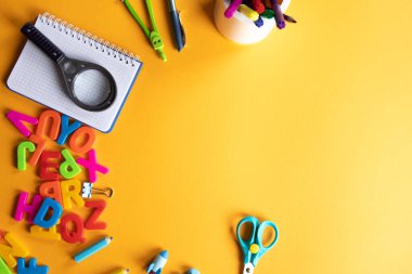 Turuncu zemin üzerine okul malzemeleri