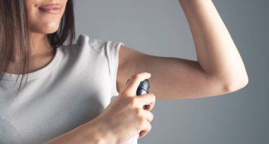 Genç kadın terleme önleyici koltuk altı kullanıyor..