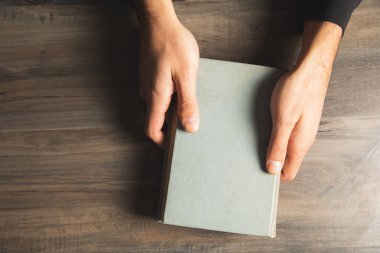 Masada kitap tutan bir adam. Yukarıdan görünüm