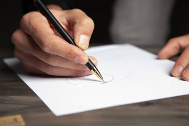 Adam kağıda not alıyor.