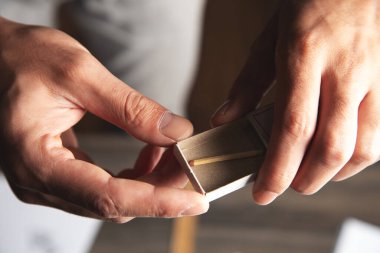 Adam ahşap bir kibrit çıkarıyor.