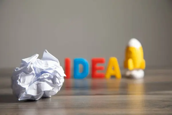 Idea Letras Papel Arrugado Cohete Sobre Mesa — Foto de Stock