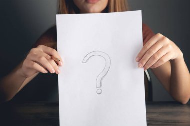 Kadın kağıda bir soru işareti çizer.