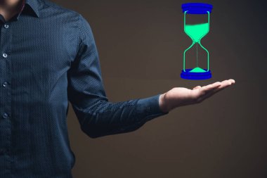 Bir adam elinde sanal bir kum saati tutar.