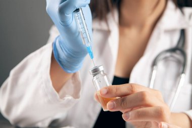 Doktor ampulden şırıngayı doldurur.