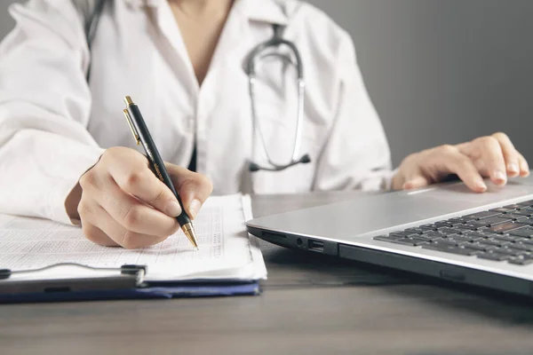 Médico Faz Anotações Sobre Papéis Frente Laptop — Fotografia de Stock